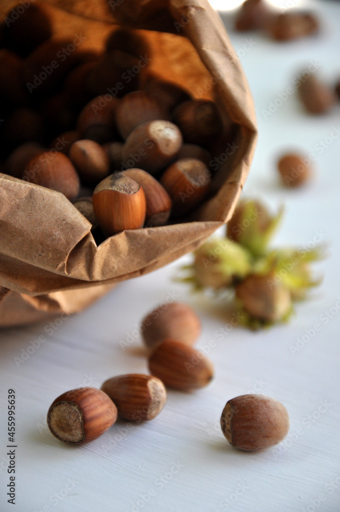 Hazelnut close-up. Hazelnuts in a paper bag on a wooden background. Hazelnut background, healthy food. Corylus. Hazelnut close-up. Hazelnuts in a paper bag on a wooden background. Hazelnut background, healthy food. Corylus.
