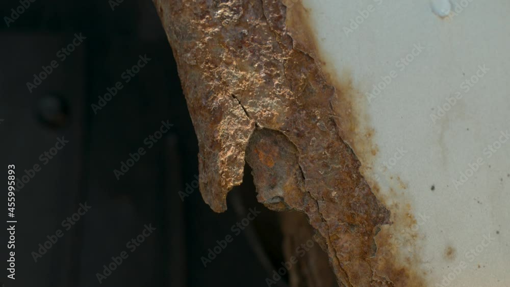 Deep rust on the body of a gray old car. Rust and corrosion hole on old worn out painted metal surface. Body parts repair. Need for repair.