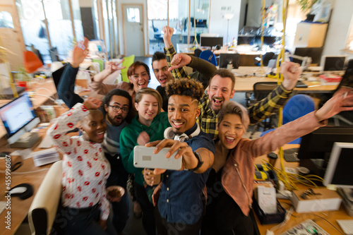 Team talking group selfie with smartphone in office