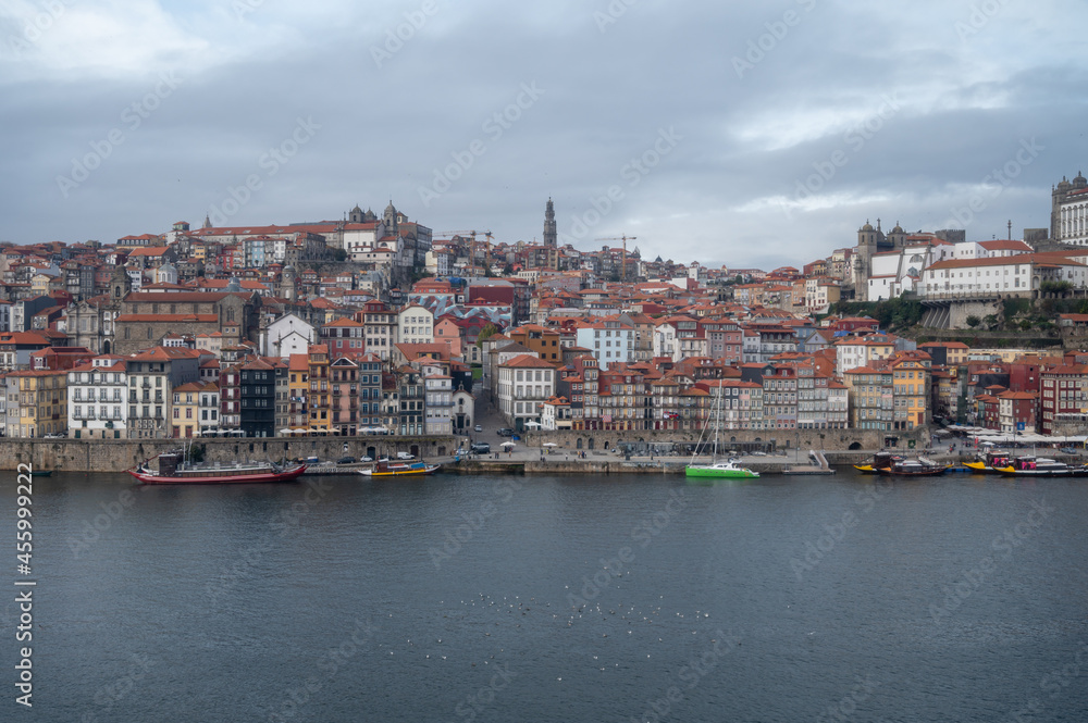 Porto, Portugal, October 31,2020. View on colorful old houses on hill in old part of city and embankment of Douro river in rainy day