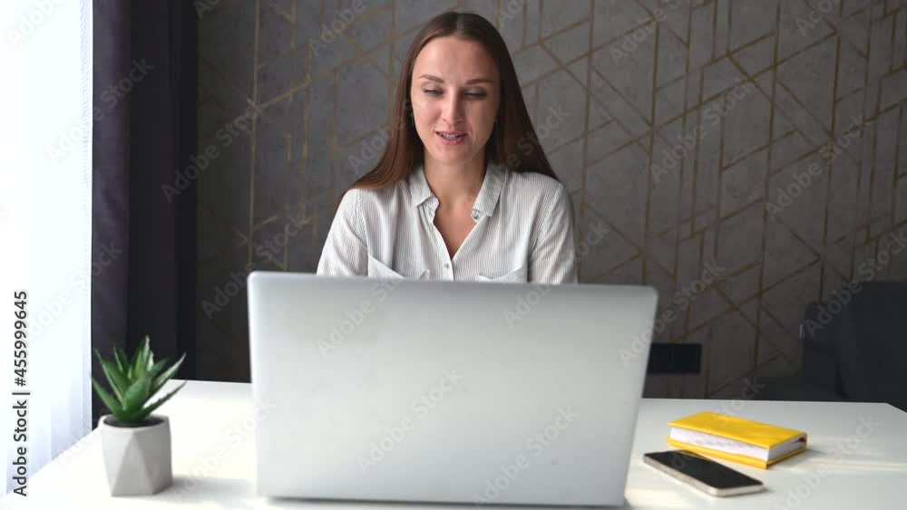 Remote meeting concept. Young female freelancer using laptop for video call, a woman in casual wear talks online, involved video conference, female student learning on the distance from home office Remote meeting concept. Young female freelancer using laptop for video call, a woman in casual wear talks online, involved video conference, female student learning on the distance from home office