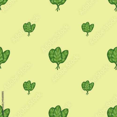 Seamless pattern bunch spinach salad on pastel yellow background. Modern ornament with lettuce.