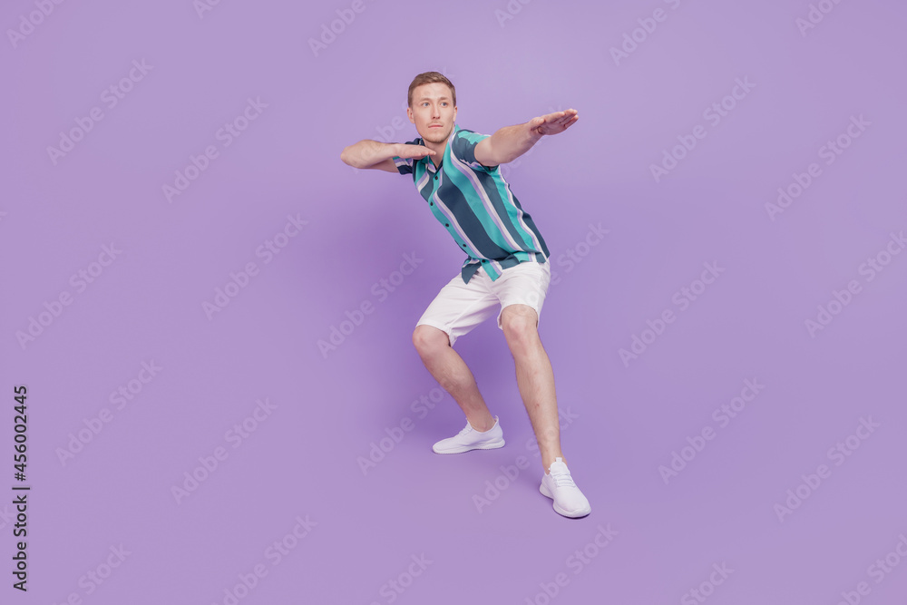 Portrait of cheerful carefree surfer tourist guy dance look empty space on violet background Portrait of cheerful carefree surfer tourist guy dance look empty space on violet background