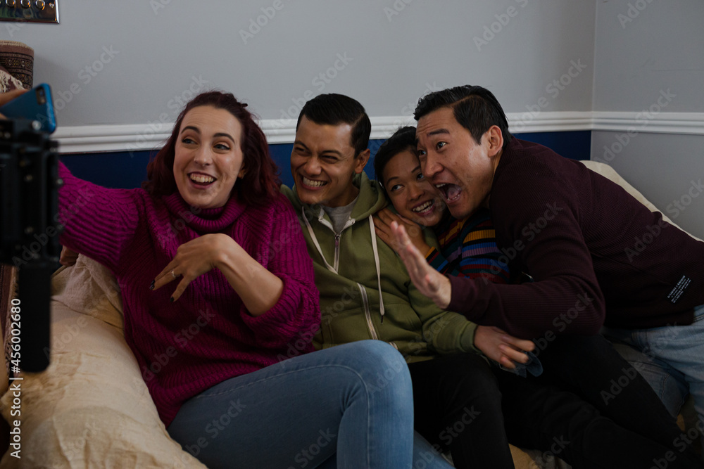 Happy friends taking a break from moving, taking selfie on sofa Happy friends taking a break from moving, taking selfie on sofa