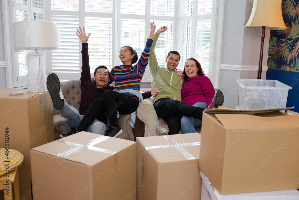 Friends taking a break from moving, relaxing in living room
