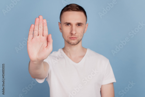 Photo of young handsome man unhappy sad show no stop sign decline refuse isolated over blue color background