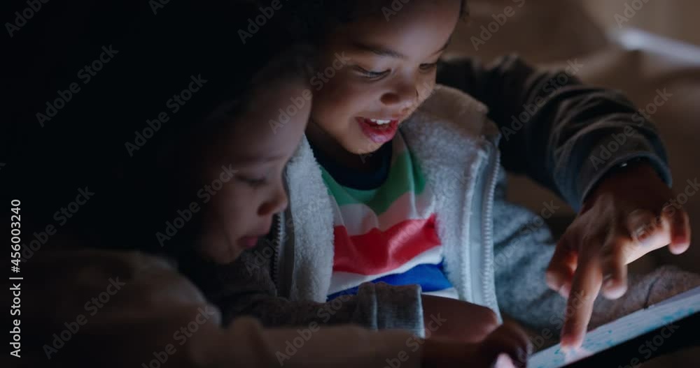 happy family using tablet computer with children mother and father watching kids play game on touchscreen technology enjoying relaxing evening before bedtime happy family using tablet computer with children mother and father watching kids play game on touchscreen technology enjoying relaxing evening before bedtime