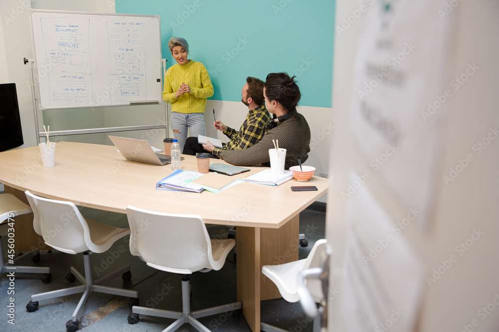 Businesswoman at whiteboard leading conference room meeting Businesswoman at whiteboard leading conference room meeting