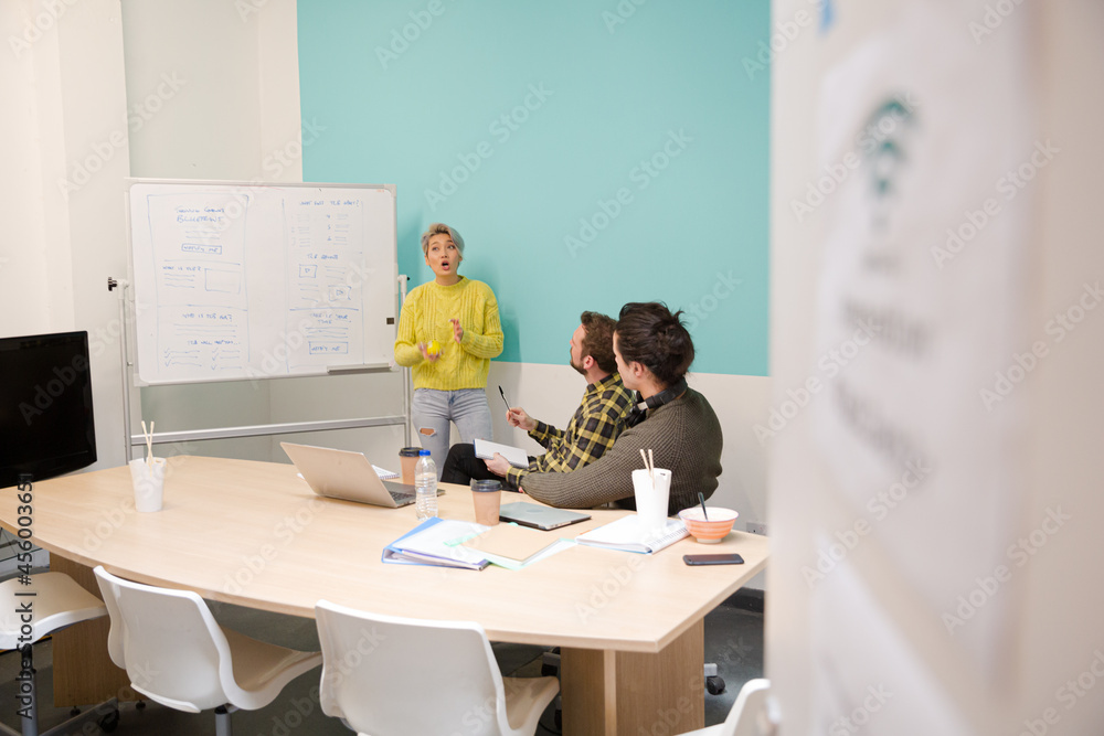 Obraz premium Businesswoman at whiteboard leading conference room meeting