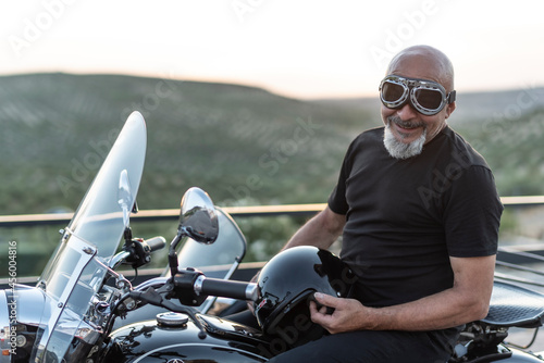 Mature man with sidecar in sunset with her bike photo