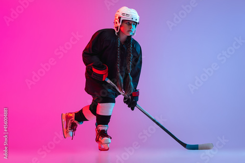 Photography Portrait of child girl - professional hockey player isolated over gradient pink
