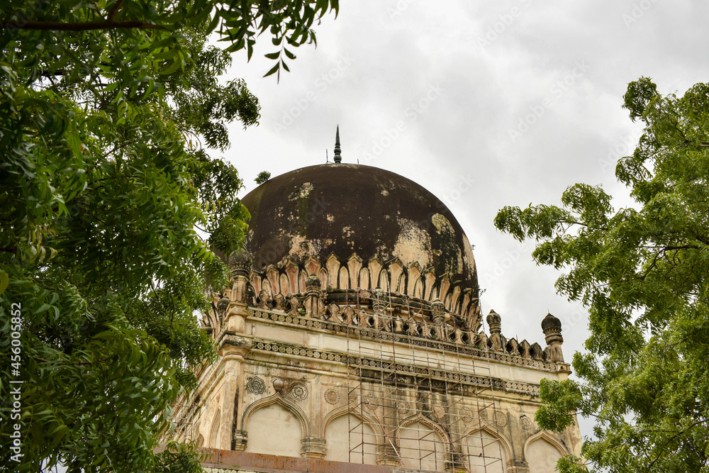 Obraz premium Antique Islamic Architectural Art Pointed Arches Seven Tombs Dome and Blue Sky Green Trees