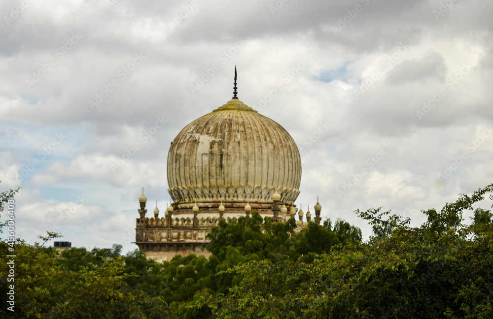 Fototapeta premium Antique Islamic Architectural Art Pointed Arches Seven Tombs Dome and Blue Sky Green Trees