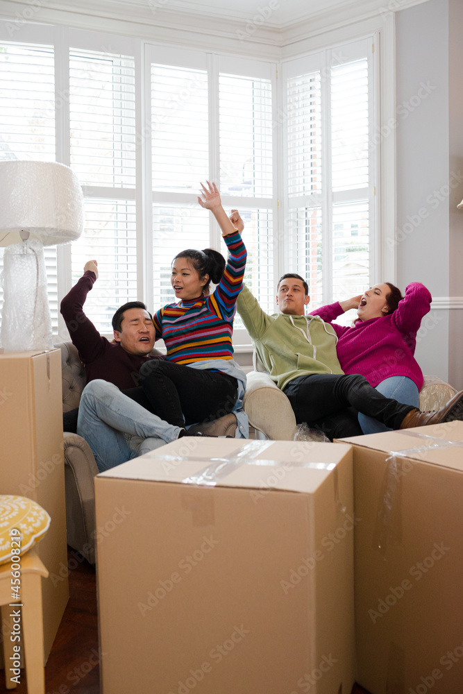 Friends taking a break from moving, relaxing in living room Friends taking a break from moving, relaxing in living room