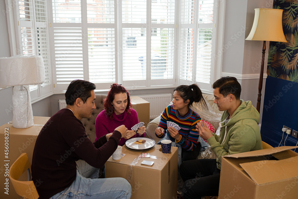 Friends taking a break from moving, playing cards Friends taking a break from moving, playing cards