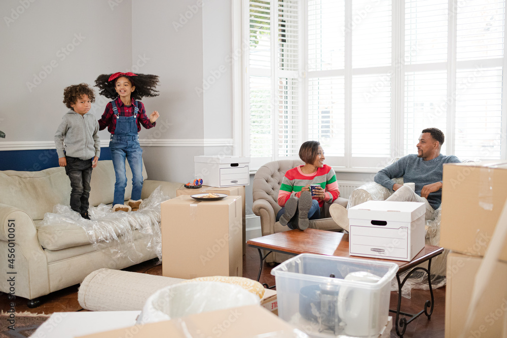 Family taking a break from moving, relaxing in living room Family taking a break from moving, relaxing in living room