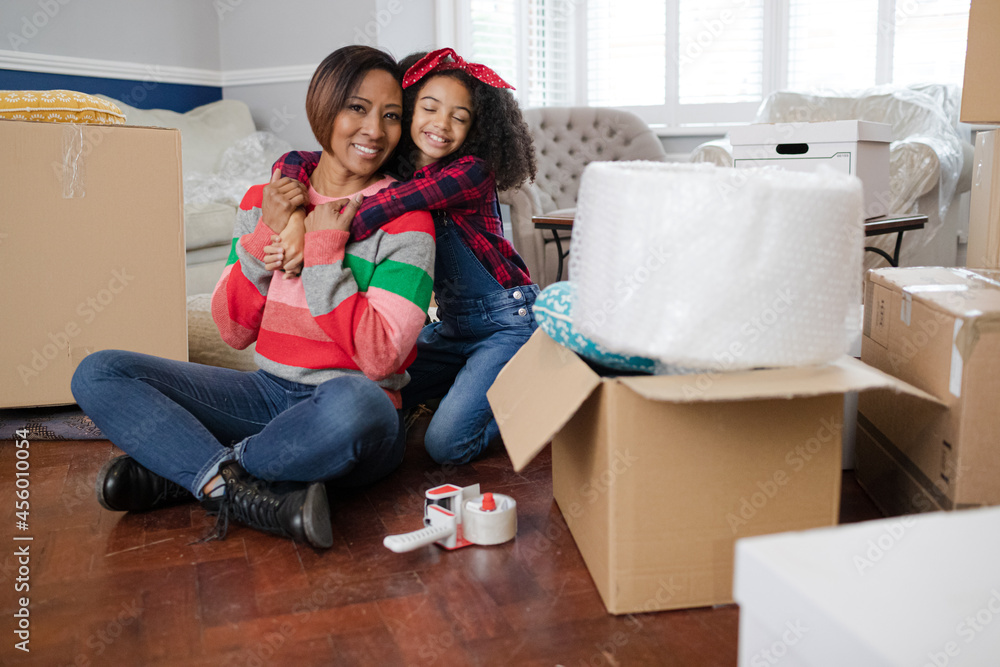 Portrait mother and daughter hugging in living room Portrait mother and daughter hugging in living room