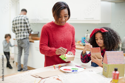 Mother and daughter painting cardboard houses