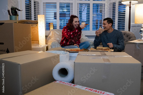 Tableau sur toile Happy couple taking a break from moving, eating pizza