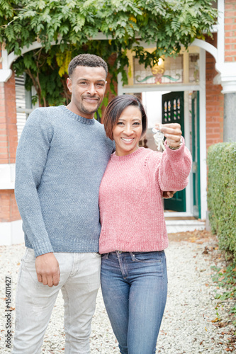 Portrait happy couple with keys to new house