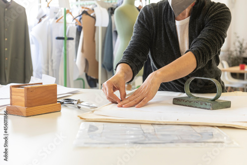 A woman draws and cuts a clothing pattern