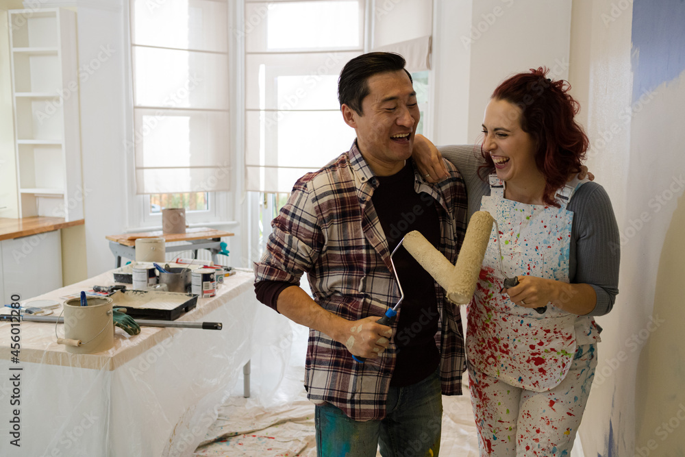 custom made wallpaper toronto digitalHappy, playful couple with paint rollers painting room