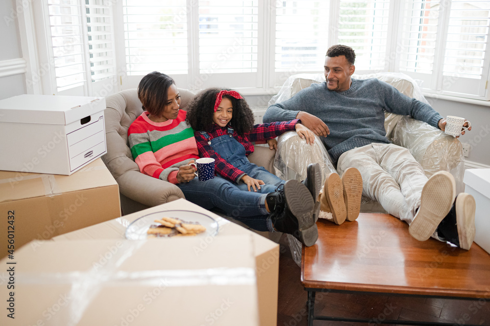 Family taking a break from moving, relaxing in living room Family taking a break from moving, relaxing in living room