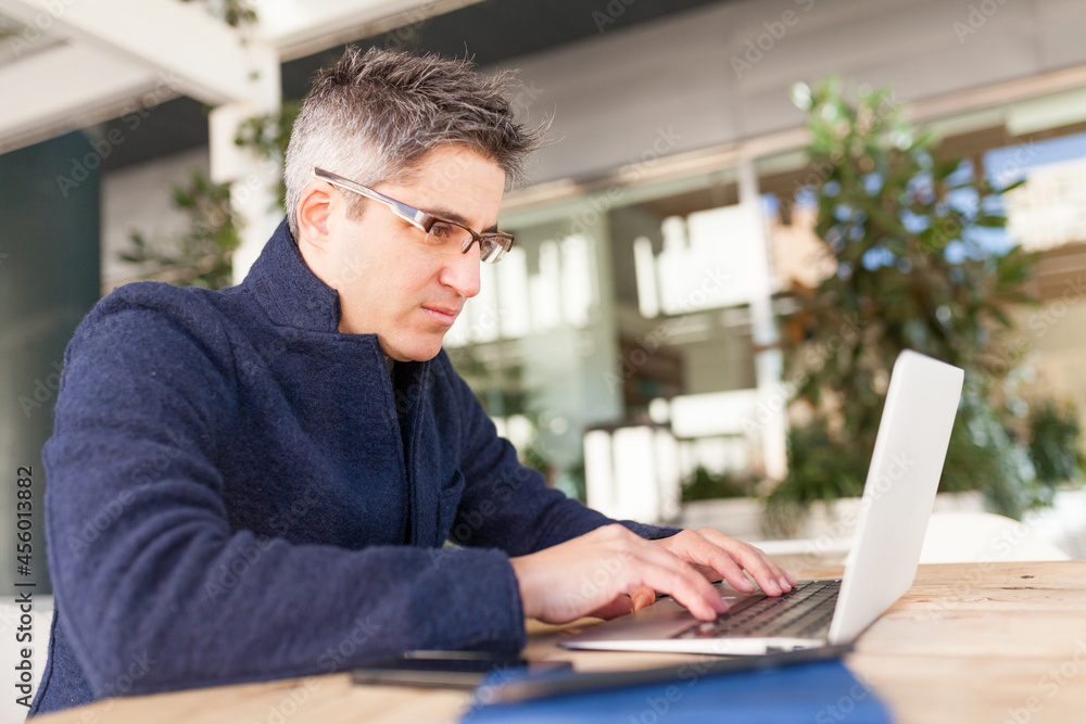 Serious man working on laptop in office Serious man working on laptop in office