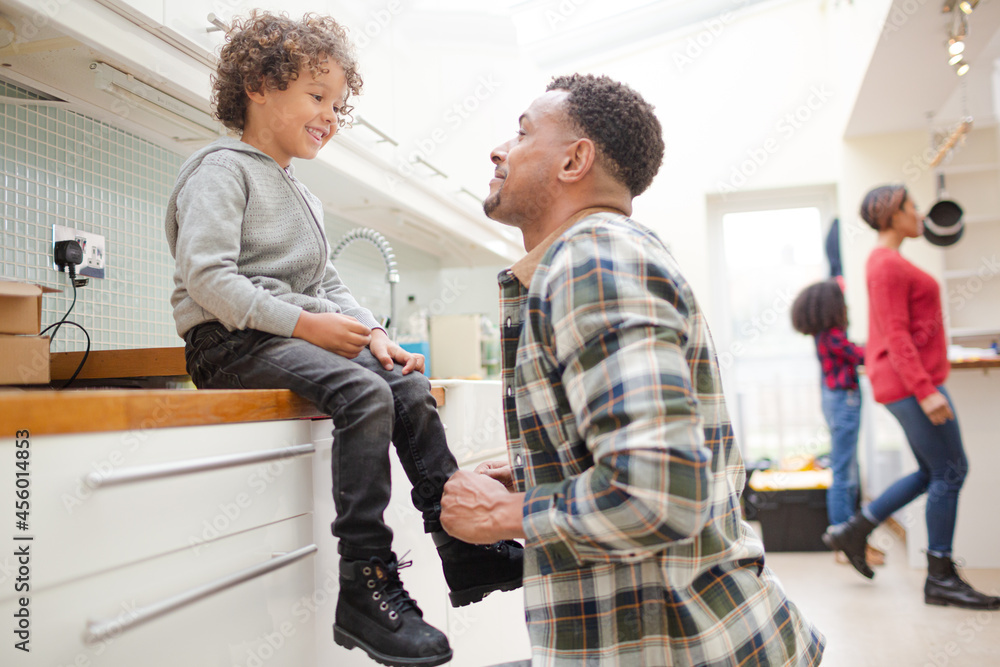 Father putting shoes on son Father putting shoes on son