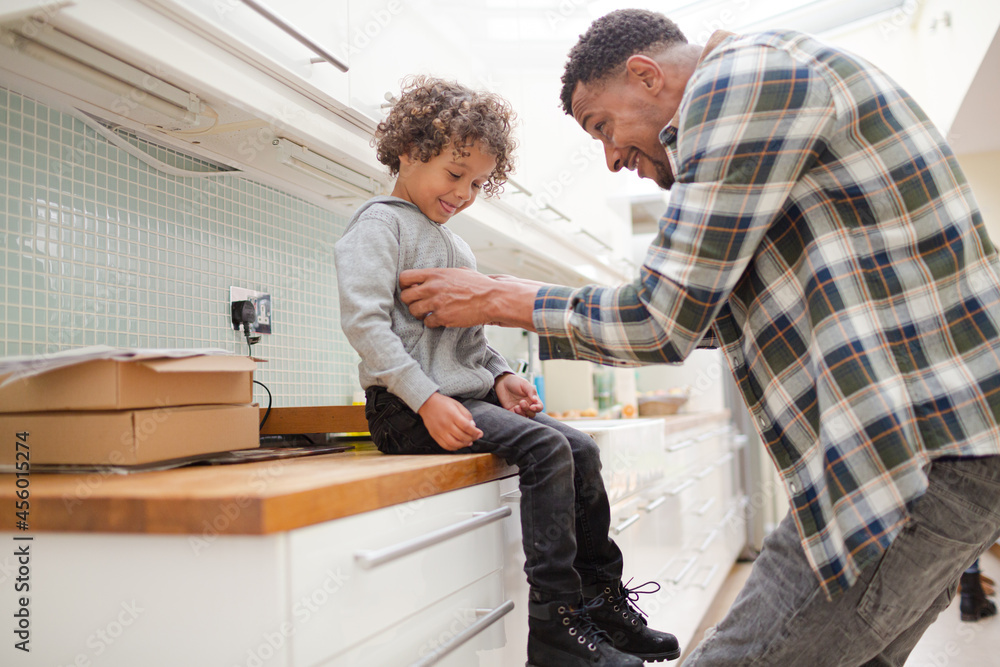 Father putting shoes on son Father putting shoes on son