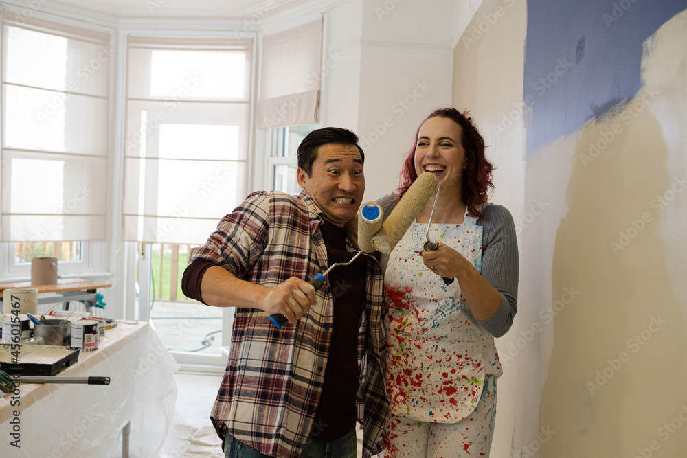 custom made wallpaper toronto digitalHappy, playful couple with paint rollers painting room