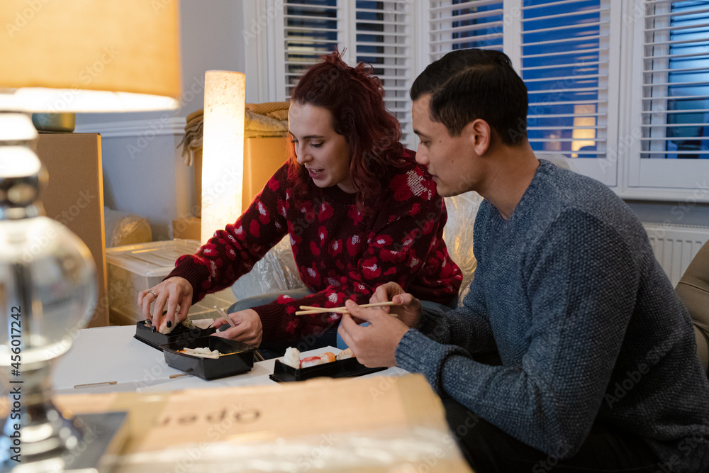 Couple taking a break from moving, eating sushi Couple taking a break from moving, eating sushi