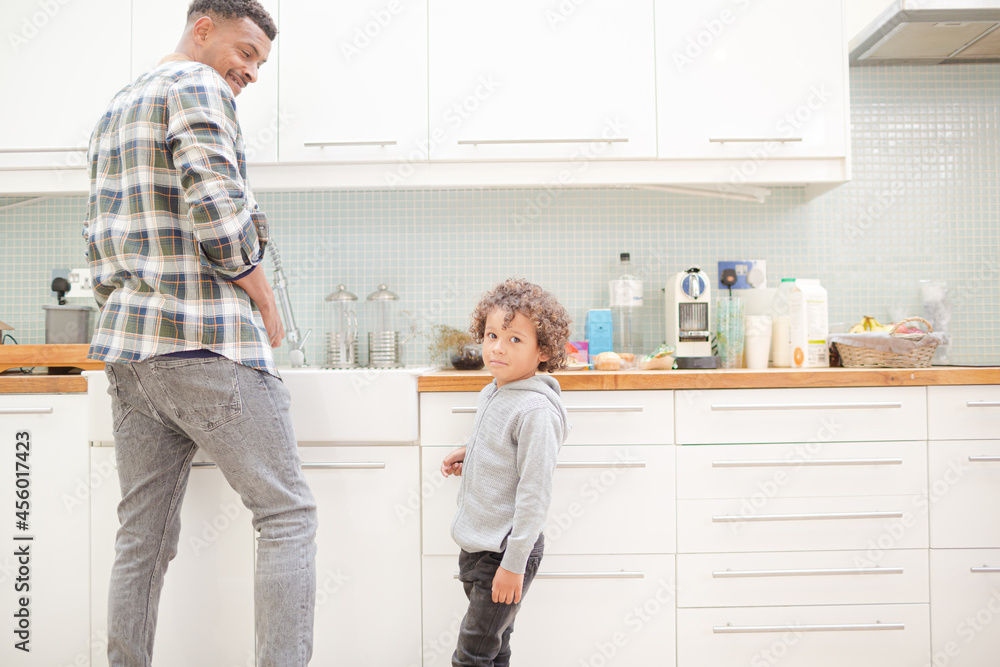 Father and son standing in kitchen Father and son standing in kitchen