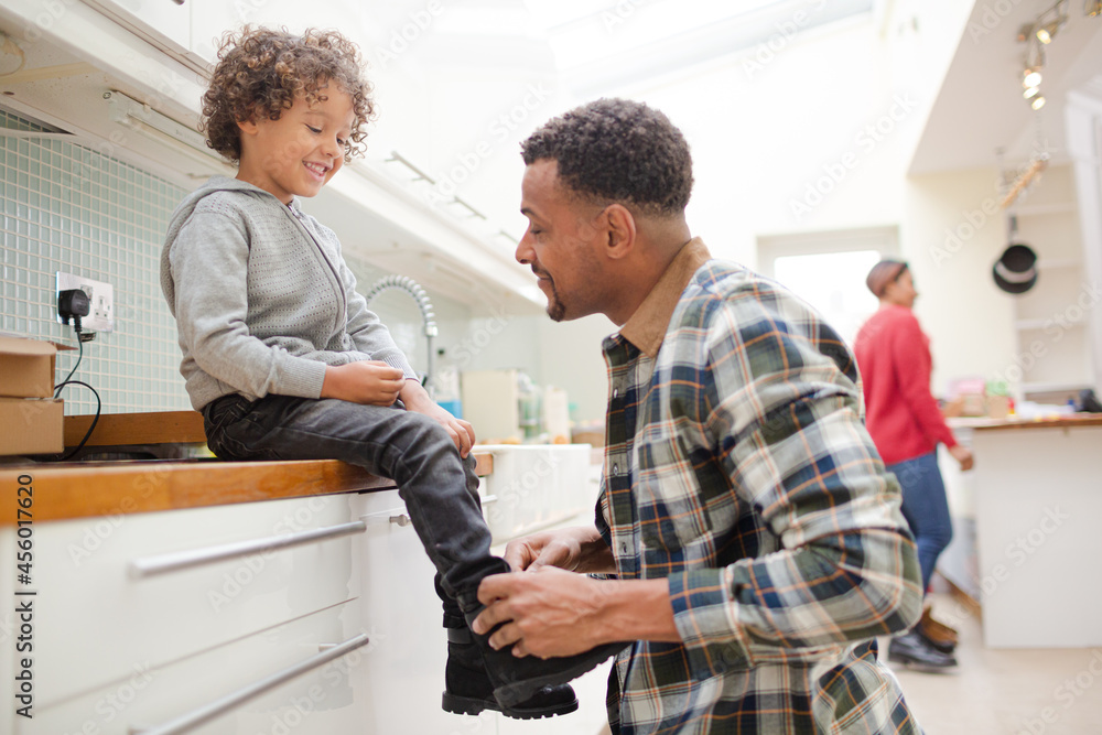 Fototapeta premium Father putting shoes on son