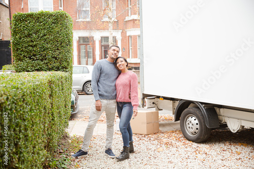 Happy couple taking a break from moving, looking at old house photo