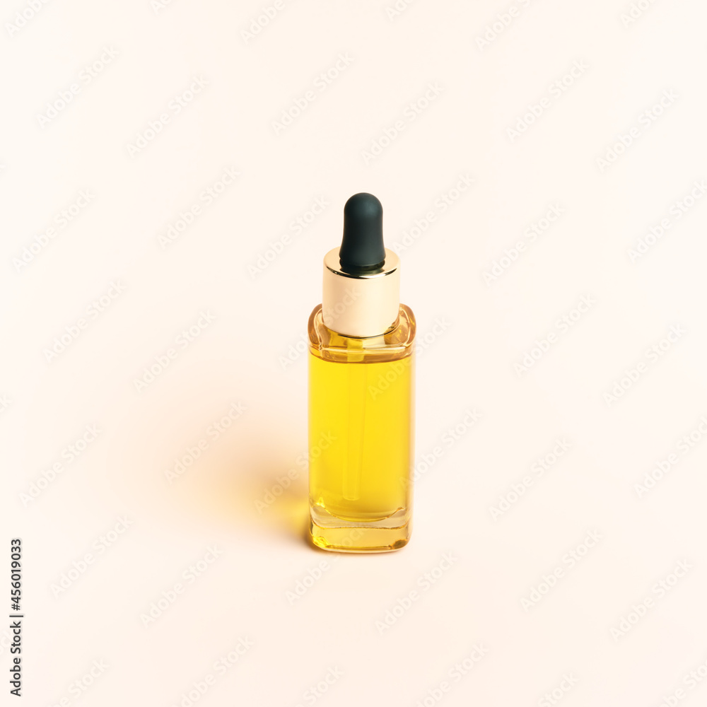 Glass dropper bottle with a pippette with black rubber tip with natural decorations on the beige background. Nature Skin concept. Organic Spa Cosmetics. Trendy concept. Front view. Glass dropper bottle with a pippette with black rubber tip with natural decorations on the beige background. Nature Skin concept. Organic Spa Cosmetics. Trendy concept. Front view.