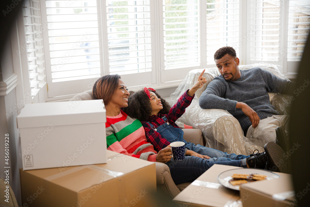 Family taking a break from moving, relaxing in living room Family taking a break from moving, relaxing in living room