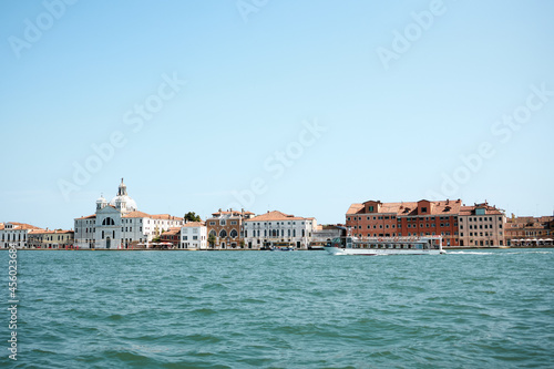 Venetian gondolier punting gondola through green canal waters of Venice Italy  © Роман Мельник