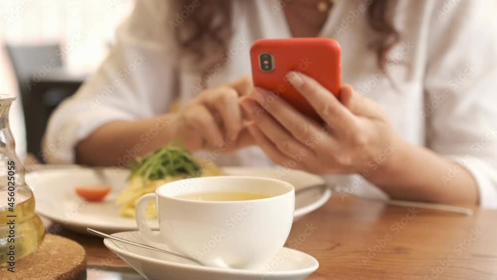 Closeup business woman typing message on mobile phone at restaurant. Close up young woman hands using smartphone . Closeup business woman typing message on mobile phone at restaurant. Close up young woman hands using smartphone .
