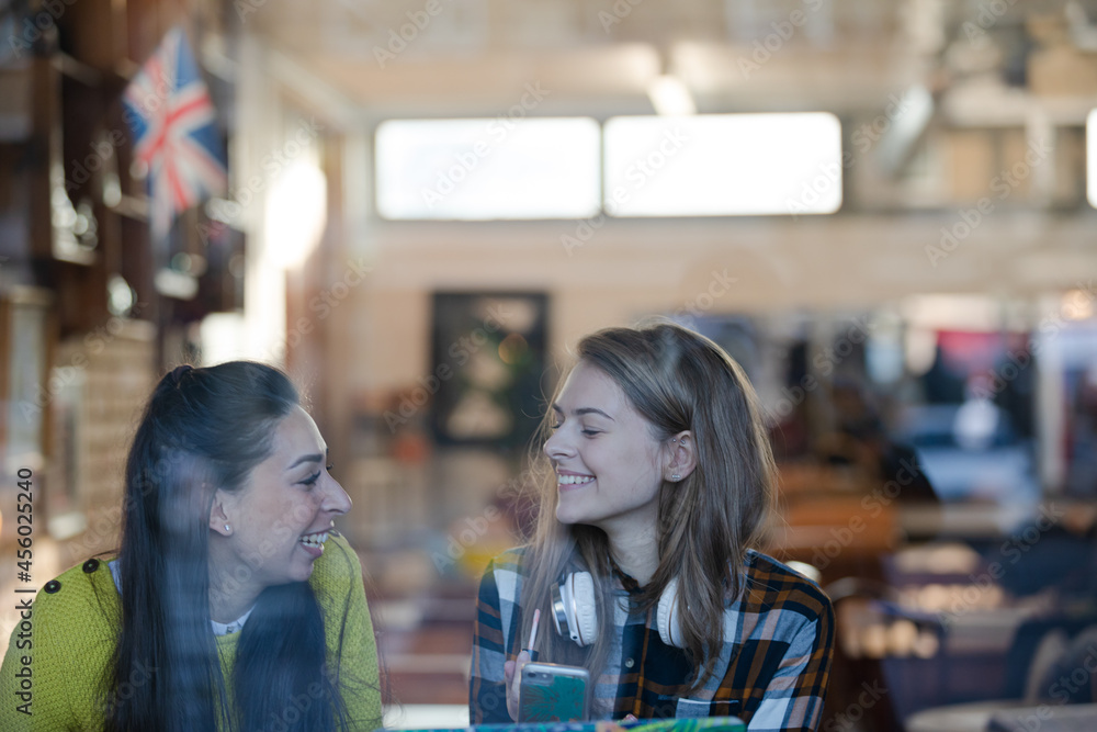Young female college students studying at cafe window Young female college students studying at cafe window