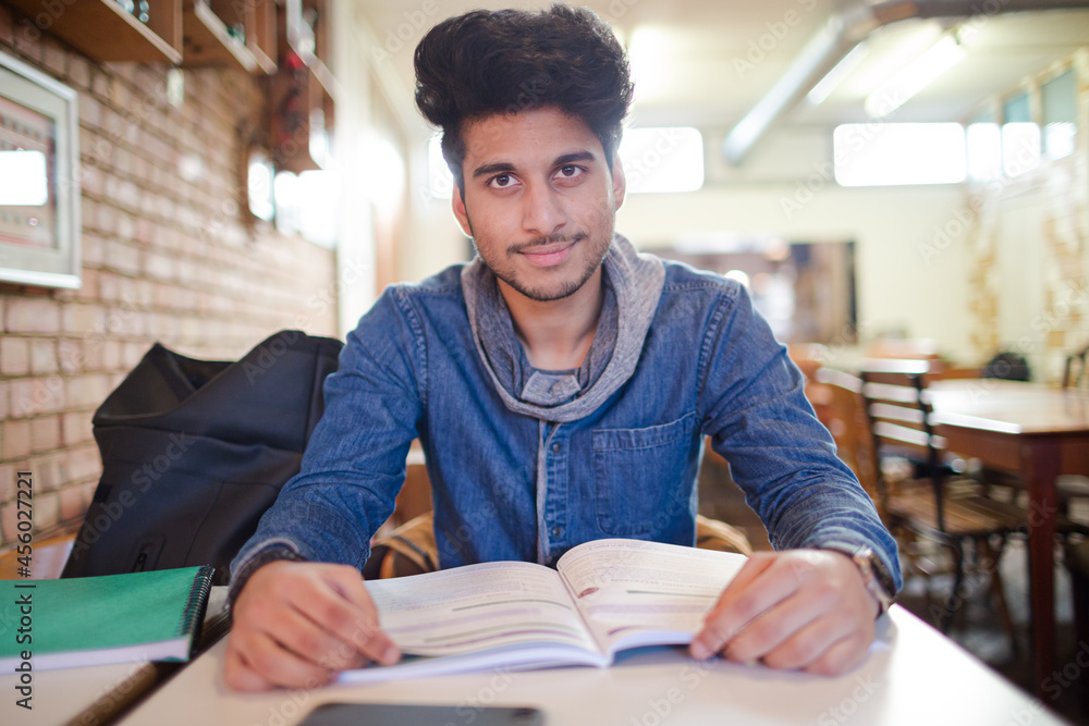 Focused young male college student studying in cafe Focused young male college student studying in cafe