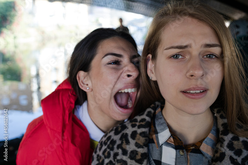 Angry young woman yelling at friend