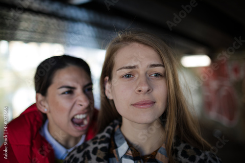 Angry young woman yelling at friend