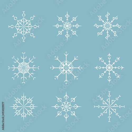 Set of winter snowflakes isolated on blue background. Celebration decor. Vector illustration.
