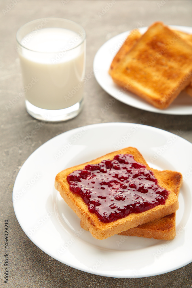 Sweet toasts with jam with milk for breakfast on grey table, vertical Sweet toasts with jam with milk for breakfast on grey table, vertical
