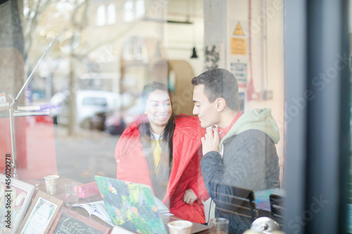 Young couple studying at cafe window