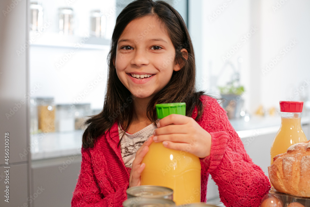 Portrait smiling girl with orange juice in kitchen Portrait smiling girl with orange juice in kitchen