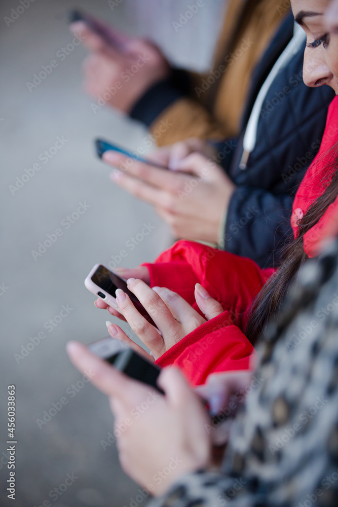 Young adult friends using smart phones Young adult friends using smart phones