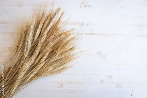 Fototapeta Naklejka Na Ścianę i Meble -  ears of wheat on a white wooden background