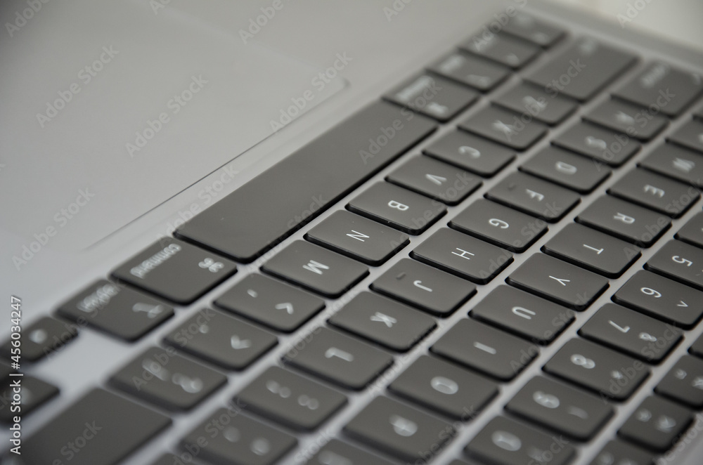 Selective focus keyboard of laptop. Side view modern ultralight device with trackpad. Selective focus keyboard of laptop. Side view modern ultralight device with trackpad.